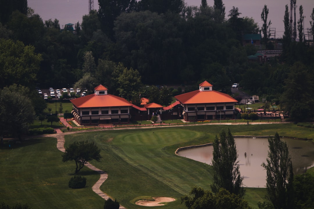 Golf course with clubhouse buildings beside a pond